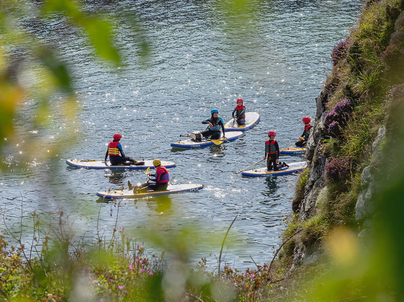 A group of paddle boarders resting near Porth Dafarch Beach