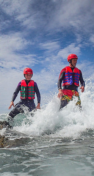 Two kids coasteering a Porth Dafarch Beach