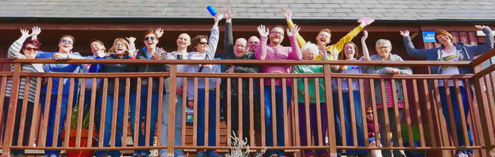 Large group of people taking a group photo on a balcony at Anglesey Outdoors